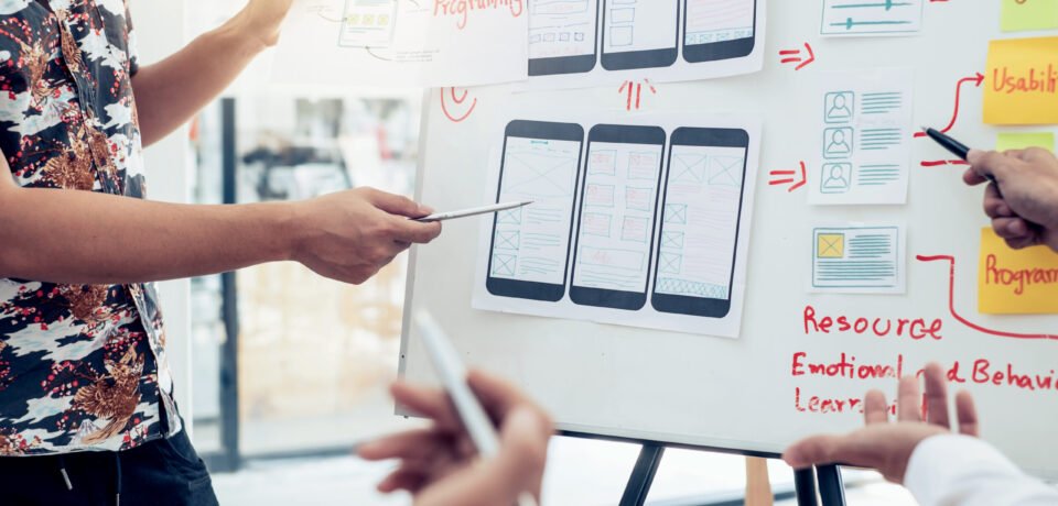 Designers planning to work together Draw application program in mobile phone and website development.