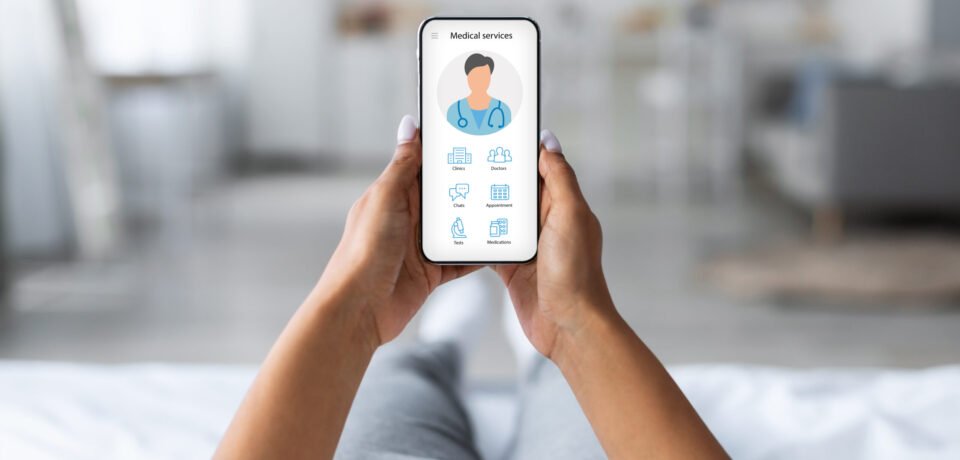 Unrecognizable woman laying on bed with mobile phone, using online medical application, chatting with doctor, home interior. Telemedicine software, modern technologies and healthcare concept