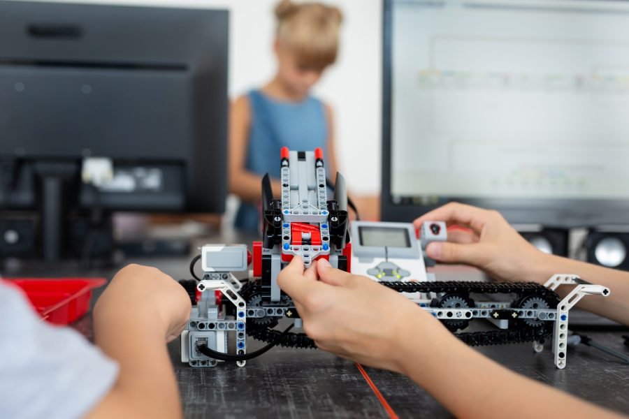 Children play with a robot in a robotics class
