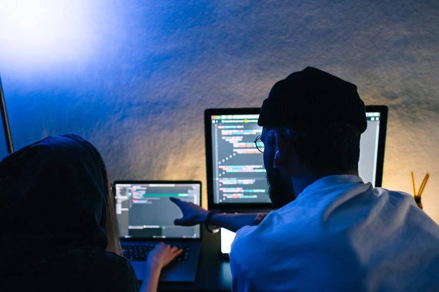 Mobile developers team writes program code on a computer, programmers work in home office. Mobile developers team writes program code on a computer, programmers work in home office.