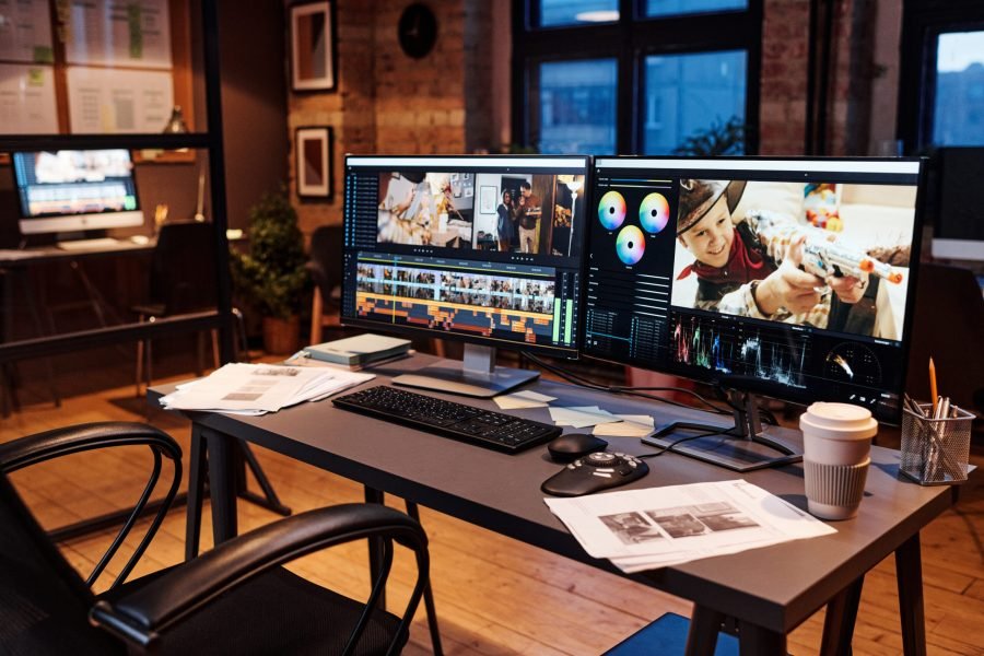 Workplace of designer with computers on table Desktop computer with photo editing software standing on the desk in the modern creative office